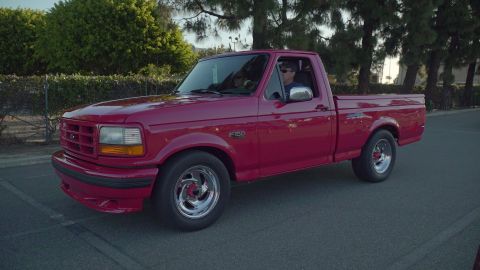1993 Ford Taurus - Side view of a red pickup truck parked on a street.