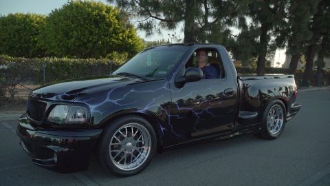 1993 Ford Taurus - This black pickup truck features a striking lightning bolt graphic design and aftermarket wheels.