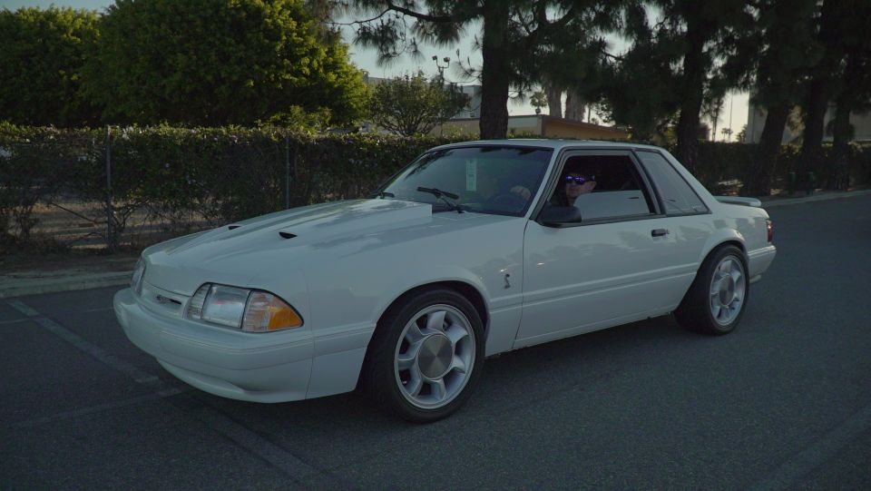 White 1993 Ford Mustang coupe with hood scoops and aftermarket wheels
