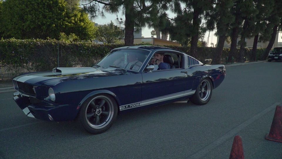 Dark blue 1966 Ford Mustang fastback with white racing stripes and "GT 350" badging