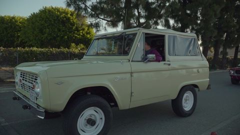 1993 Ford Taurus - A first-generation Ford Bronco, likely from the mid-1970s, is seen driving alongside another vehicle.