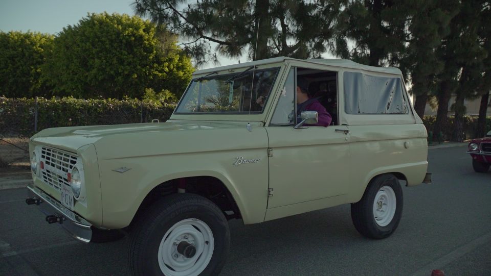 Pale yellow first-generation Ford Bronco with a white hardtop