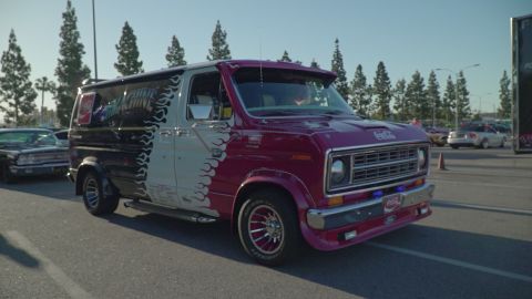 1993 Ford Taurus - A customized van with a two-tone paint job and flame decals is parked outdoors.