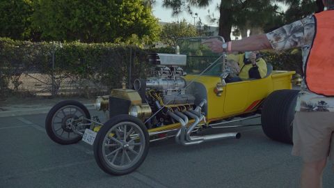 1993 Ford Taurus - A bright yellow hot rod, likely a custom build, is shown with its massive engine and prominent exhaust pipes.