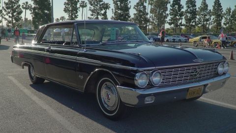 1993 Ford Taurus - A dark blue 1961 Ford Galaxie coupe is parked at an outdoor car show with other vehicles visible.