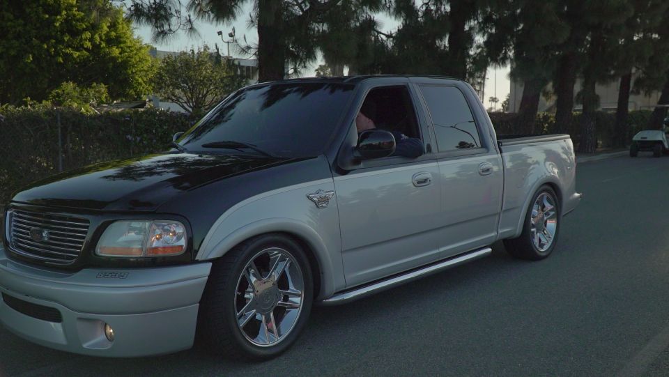 Silver and black pickup truck with chrome wheels, 3/4 front view