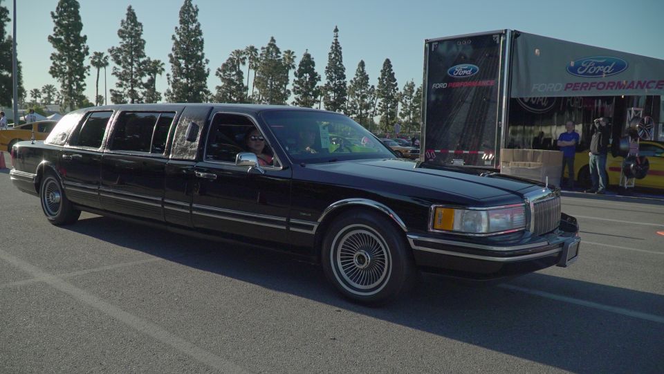 Black limousine with chrome trim, seen from a 3/4 front angle
