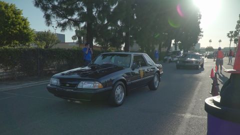 1993 Ford Taurus - Black coupe driving on a sunny day with another vehicle in the background.