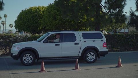 1993 Ford Taurus - A white Ford Explorer Sport Trac pickup truck is seen from the side, navigating around traffic cones.