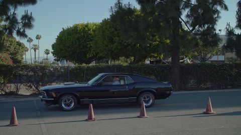 1993 Ford Taurus - A black 1970 Ford Mustang Mach 1 is seen driving on a sunny day, with traffic cones marking a path.