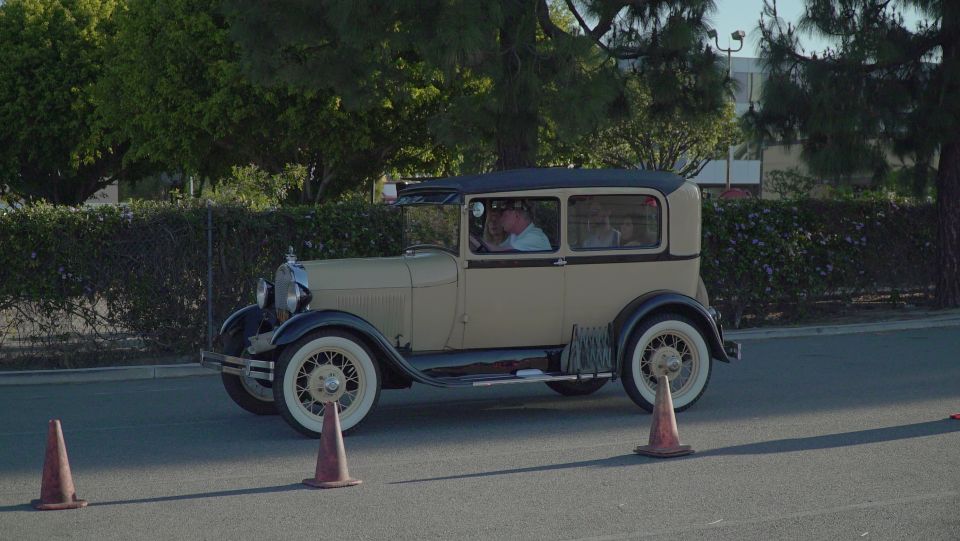 1928 Ford Model A sedan driving past traffic cones