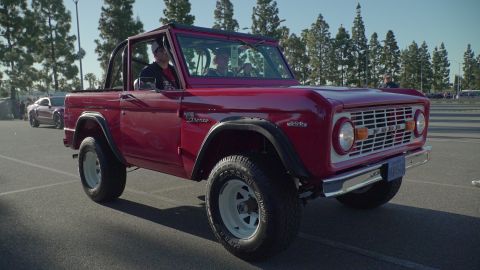 1993 Ford Taurus - A classic red first-generation Ford Bronco is seen at a car show, with another vehicle visible in the background.
