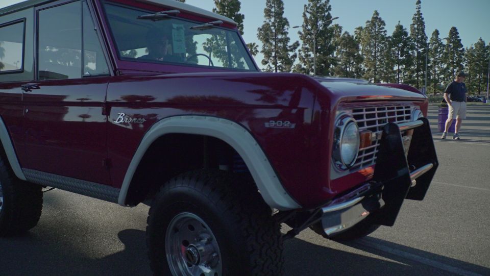 Maroon Ford Bronco with a chrome grille and black brush guard
