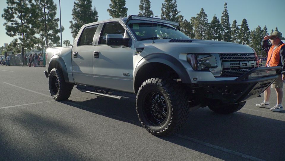 Silver Ford F-150 Raptor with custom bumper and light bar