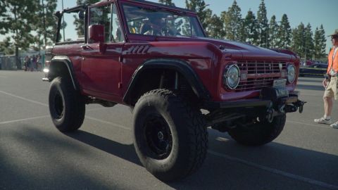 1993 Ford Taurus - A classic red Ford Bronco is displayed at an outdoor car show.
