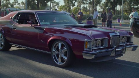 1993 Ford Taurus - A burgundy 1974 Mercury Cougar is seen from the front-three-quarter view at a Ford car show.