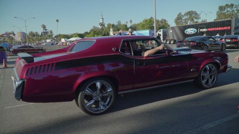1993 Ford Taurus - A classic Ford Cougar is seen at a car show, with modern Mustangs in the background.