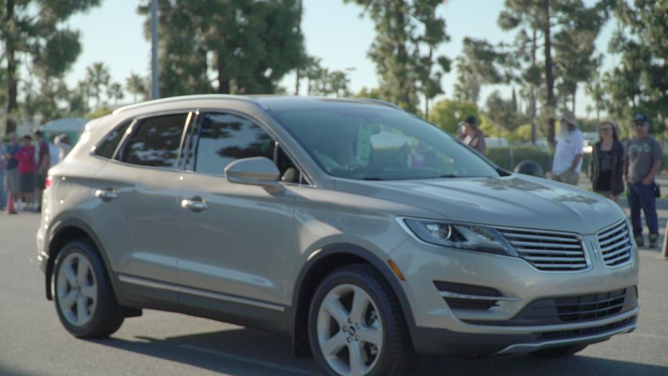 Tan Lincoln MKC parked outside with people in the background
