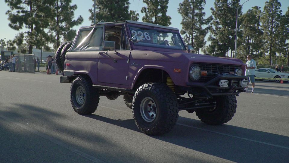 Purple Ford Bronco with a spare tire on the back, lifted suspension, and off-road tires