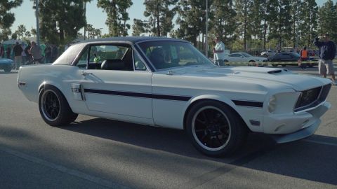 1993 Ford Taurus - A white 1967 Ford Mustang Fastback with black racing stripes is seen at an outdoor car show.