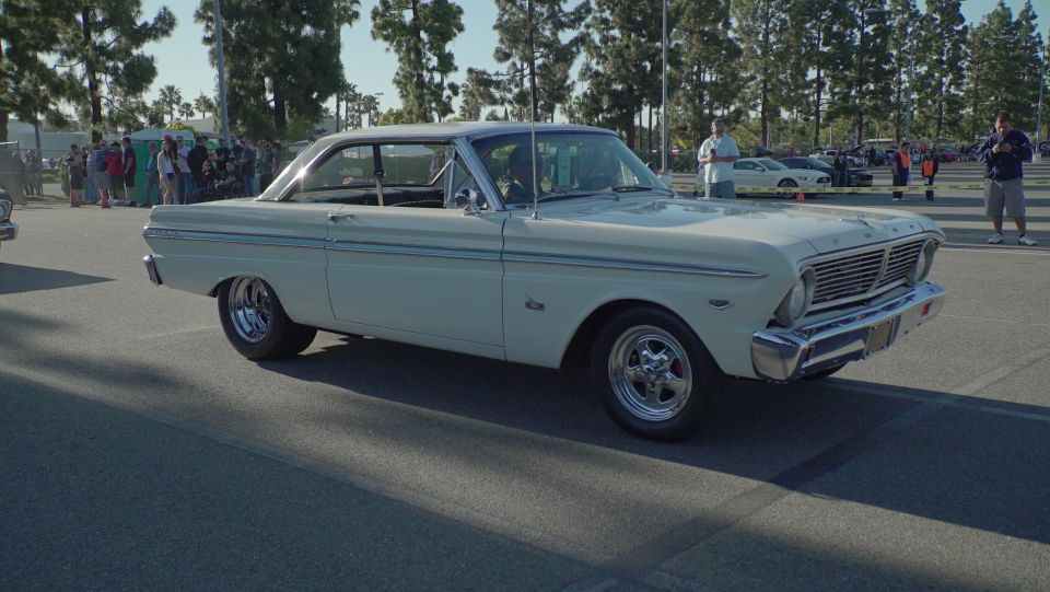 Cream-colored classic Ford coupe with chrome trim and custom wheels parked outdoors.