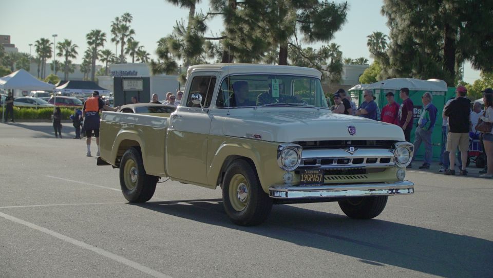 Tan and white vintage pickup truck with chrome grille and California license plate.