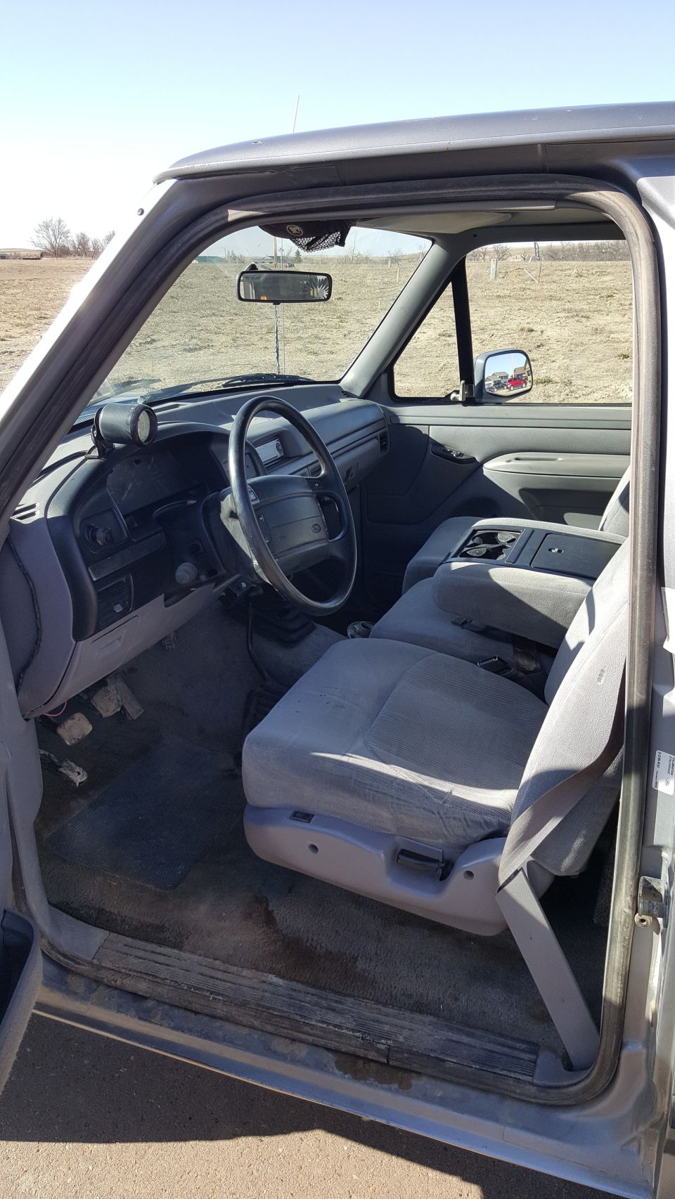Interior view of a 1995 Ford F-150 pickup truck, showing the dashboard, steering wheel, and seats.