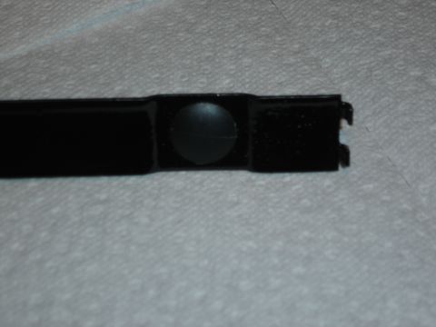 1996 Ford Bronco - A close-up view of a black plastic trim piece a circular indentation.