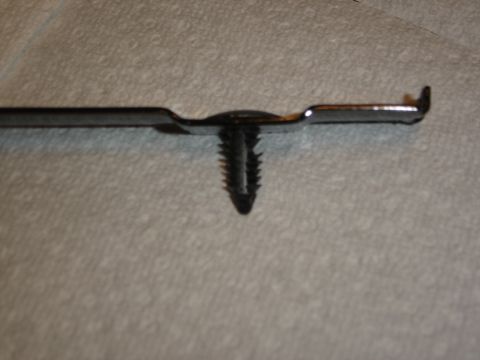 1996 Ford Bronco - Close-up of a plastic trim clip with a metal fastener attached, Supermotors.net logo in corner.