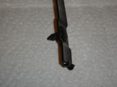 1996 Ford Bronco - A black metal bracket with a screw is shown against a textured background.