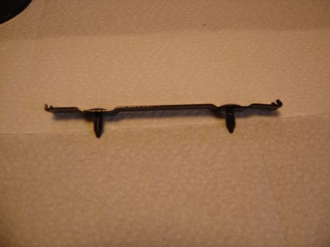 1996 Ford Bronco - A metal bracket with two plastic clips is shown against a textured background.