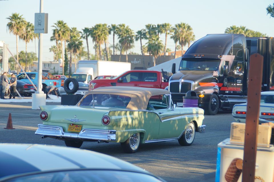 Light green 1950s convertible classic car with tan top, rear view.