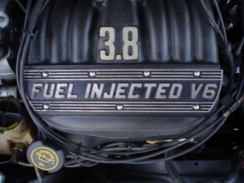 1989 Lincoln Continental - Close-up of an engine valve cover showing "3.8 FUEL INJECTED V6" markings.
