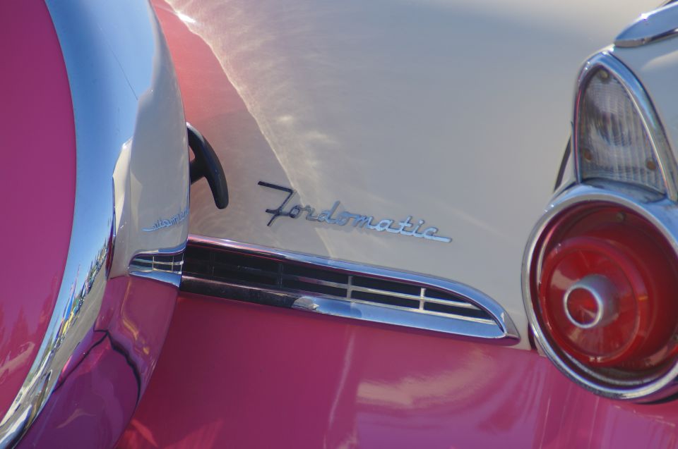 Close-up of a vintage pink and cream Ford with "Fordomatic" emblem and taillight.