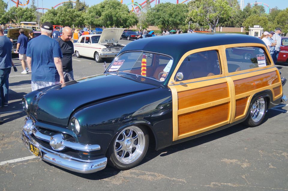 Dark green and wood-paneled station wagon with chrome accents and custom wheels.
