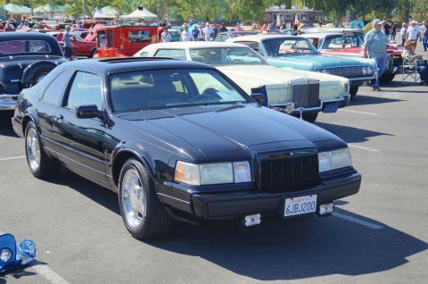 Black coupe with sunroof and California license plate 6JBJ200 parked at a car show.