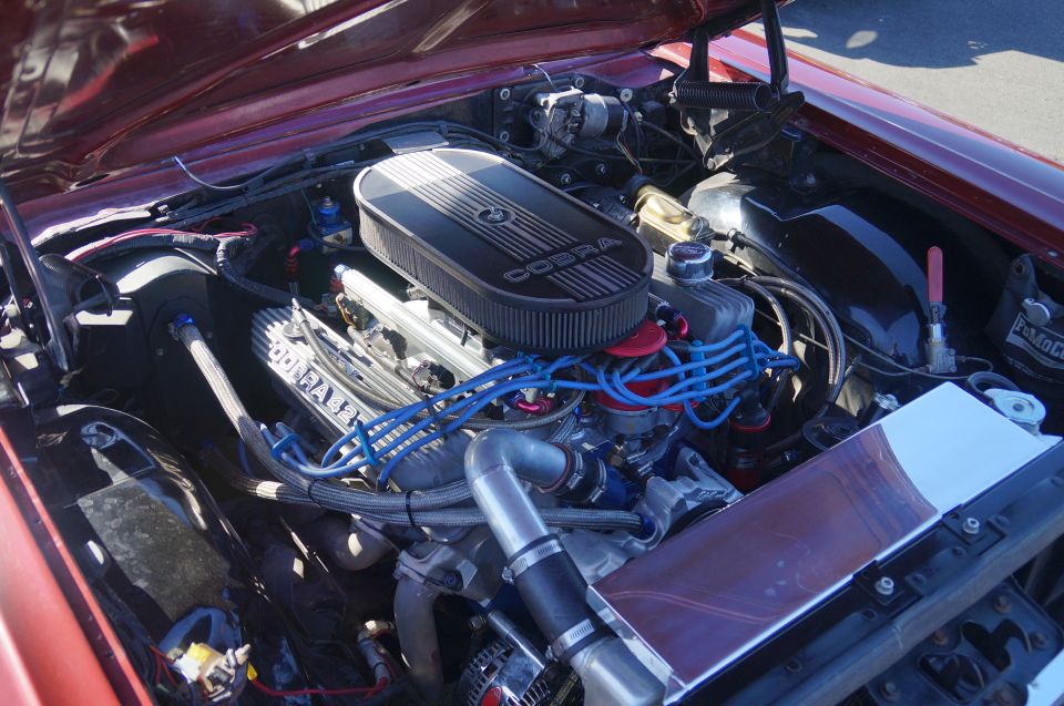 Modified V8 engine bay with Cobra air cleaner and polished valve covers.