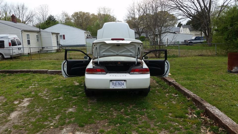 Rear view of a white 1998 Honda Prelude with hood and trunk open. License plate Vlk-7624.