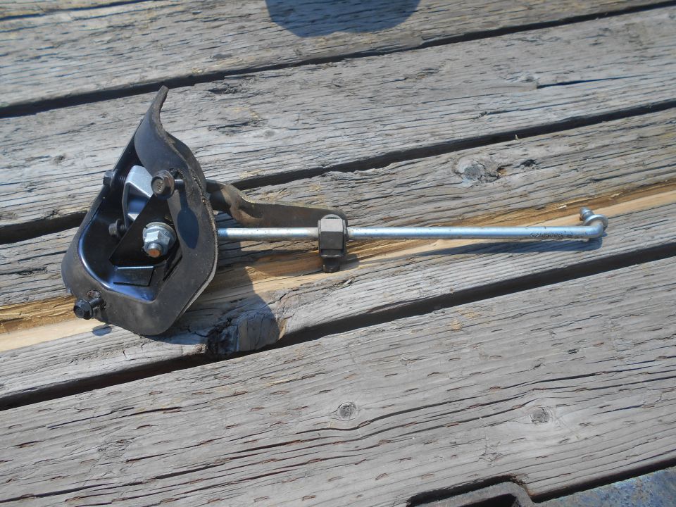 Clutch pedal assembly from a 1995 GMC Safari on a wooden surface