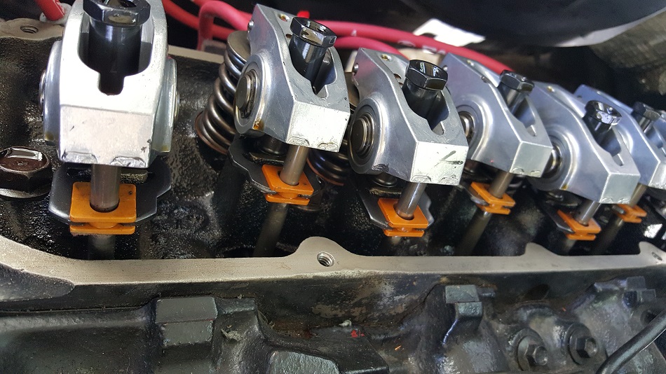 Close-up of V8 engine valve train with rocker arms, springs, and pushrods.
