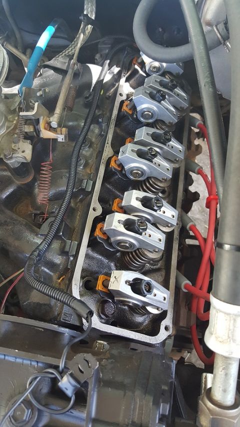 1978 Ford Bronco - A close-up view of the rocker arms and valve springs inside a V8 engine. Several silver rocker arms with black adjustment nuts are visible,…