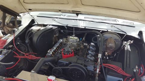 1978 Ford Bronco - A detailed view of the engine bay of a classic Ford Bronco, showcasing the V8 engine, carburetor, distributor, and various hoses and wiring.