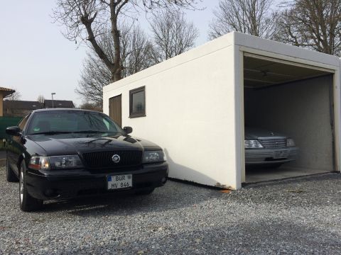 1999 Ford Fairlane - A black Mercury Grand Marquis sedan is parked on a gravel driveway in front of a white garage. Another silver car is visible inside the gar…