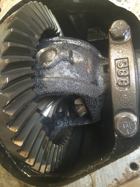 1981 Ford Bronco - A close-up view inside a differential housing shows a ring gear and pinion gear assembly. The gears appear to have black sludge or debris o…