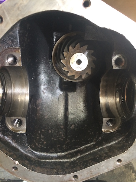 1981 Ford Bronco - The inside of a differential housing shows a ring gear with a pinion gear mounted on top. The pinion gear has markings that appear to read…