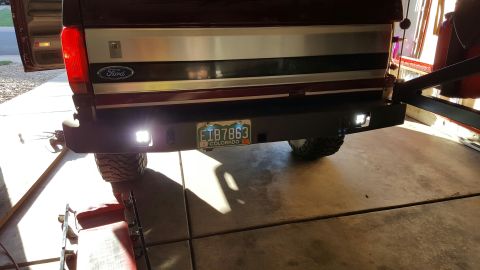 1996 Ford Bronco - The rear of a dark red Ford Bronco is shown with a custom black bumper featuring two bright LED reverse lights. A Colorado license plate is…