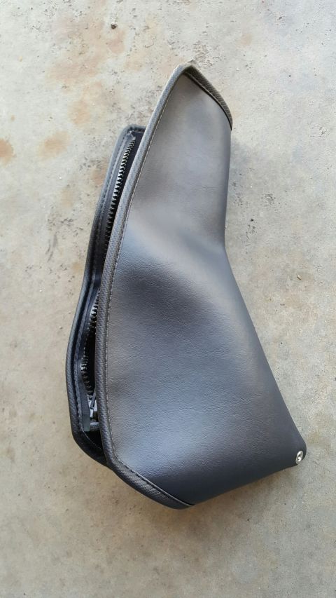 1996 Ford Bronco - A black leather gear shift boot with a zipper closure is shown lying on a concrete surface. The boot has a textured trim along its edges an…