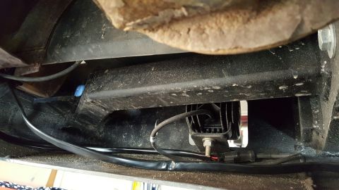 1996 Ford Bronco - A close-up, low-angle view shows the underside of a vehicle, focusing on a black LED light bar mounted to a metal bracket. Wiring is visibl…