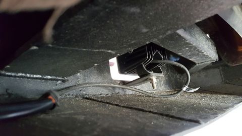 1996 Ford Bronco - A black LED light bar is mounted underneath the vehicle, secured by a bracket and bolt. A black wire with an orange connector runs from the…