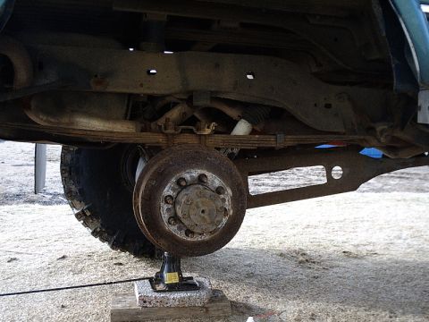 1996 Ford Bronco - Close-up view of the rear axle and suspension system of a 1996 Ford Bronco, showing leaf springs and a drum brake assembly.